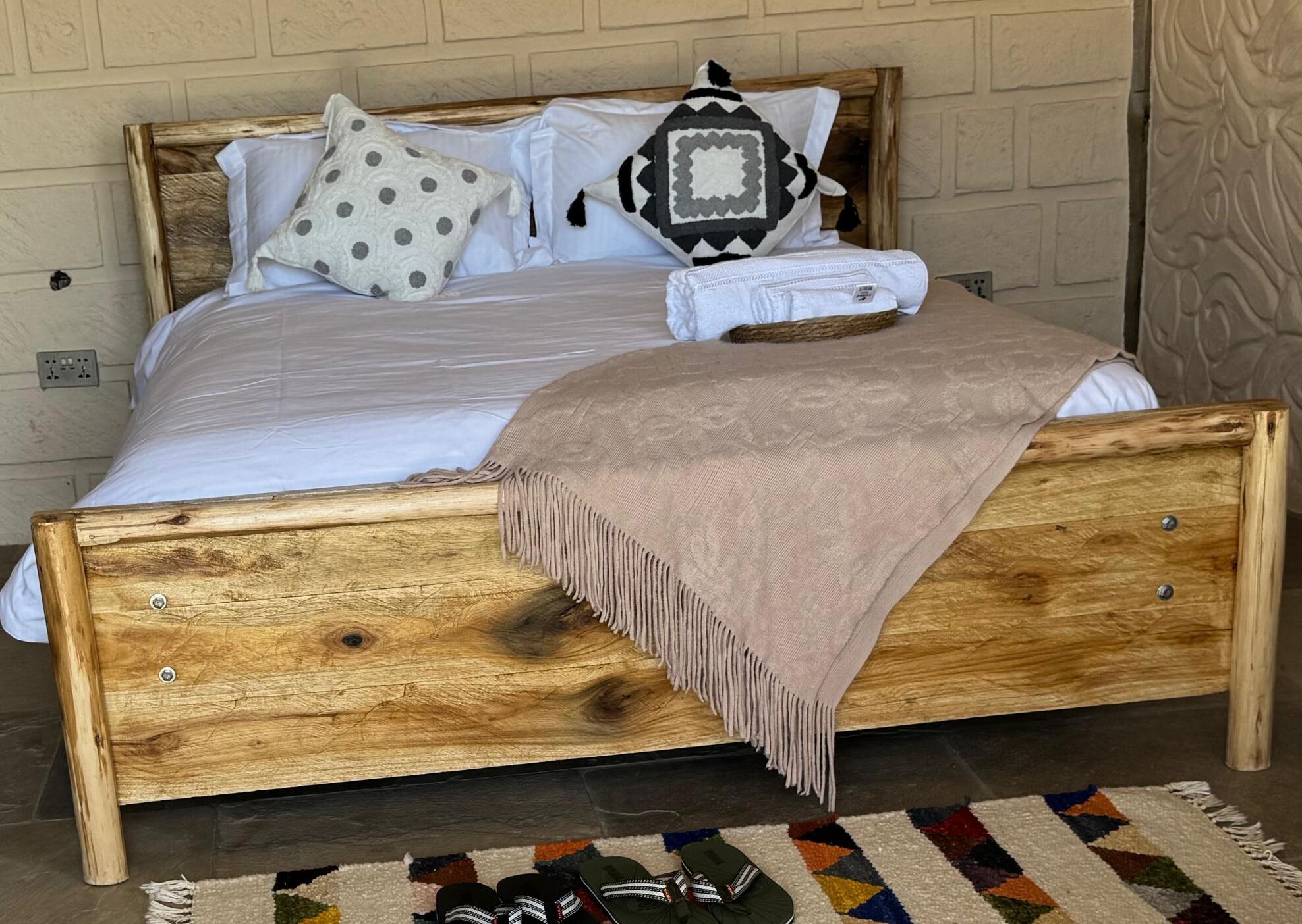 Timber bed with linen and a knitted throw
