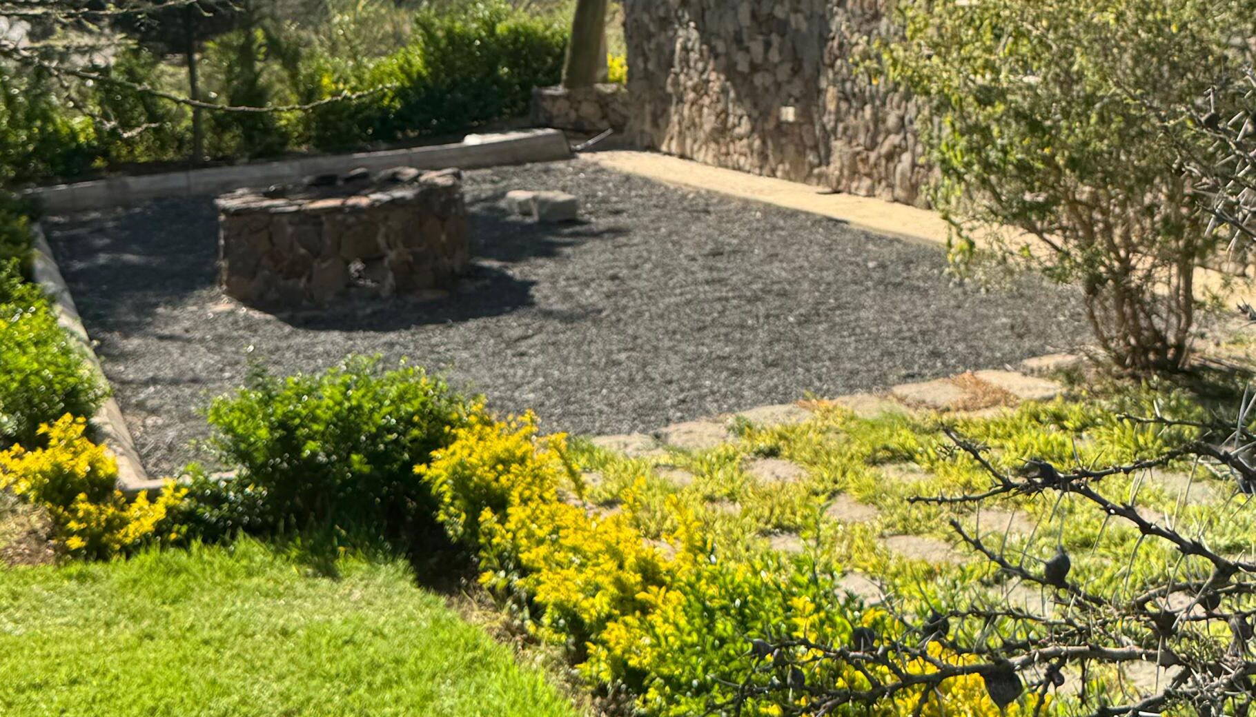 Stone fire pit surrounded by garden